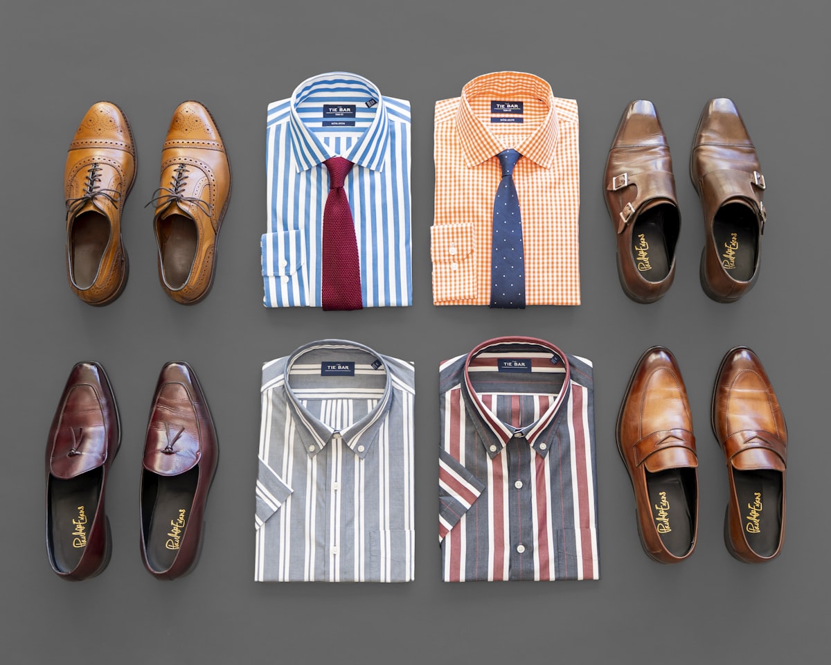 Dapper Professional flatlay of men's fashion for spring and summer items. Including, bold gingham shirts, bold stripe shirts, knit ties, and bold vertical stripe short sleeve button downs. Bold shoes include loafers and double monks. related to Transforming First Impressions: Stylish Entryway Closet Ideas