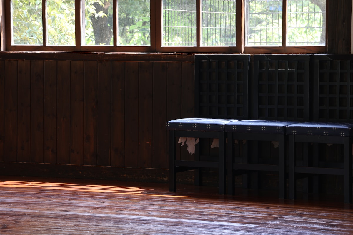 Dark wooden benches in a room with sunlight. related to Elevate Your Home's First Impression with an Entryway Bench with Back