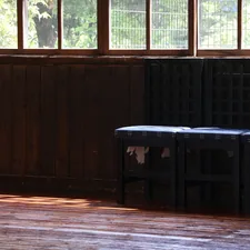 Dark wooden benches in a room with sunlight. related to Elevate Your Home's First Impression with an Entryway Bench with Back