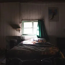 Dimly lit bedroom with a bed and window related to Charming Escapes: Exploring Farm Bed and Breakfasts