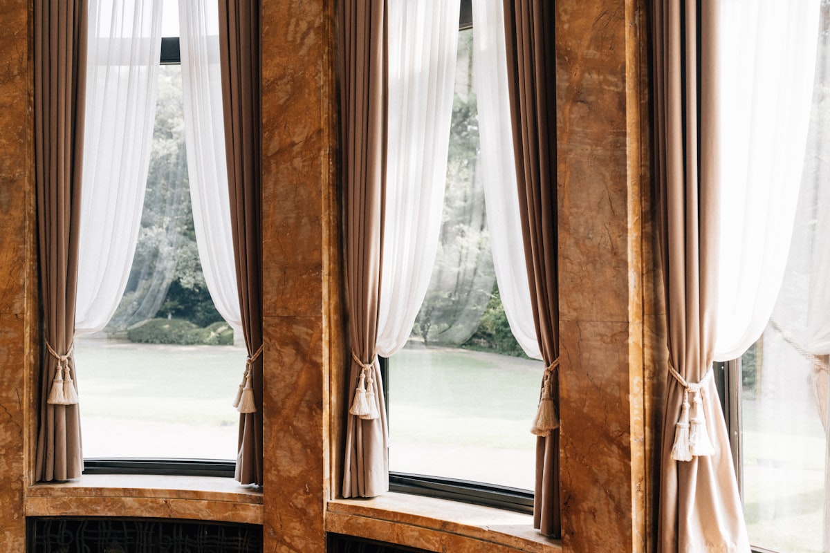 Elegant curtains framing a view of greenery related to The Art of Window Dressing: Valances and Swags