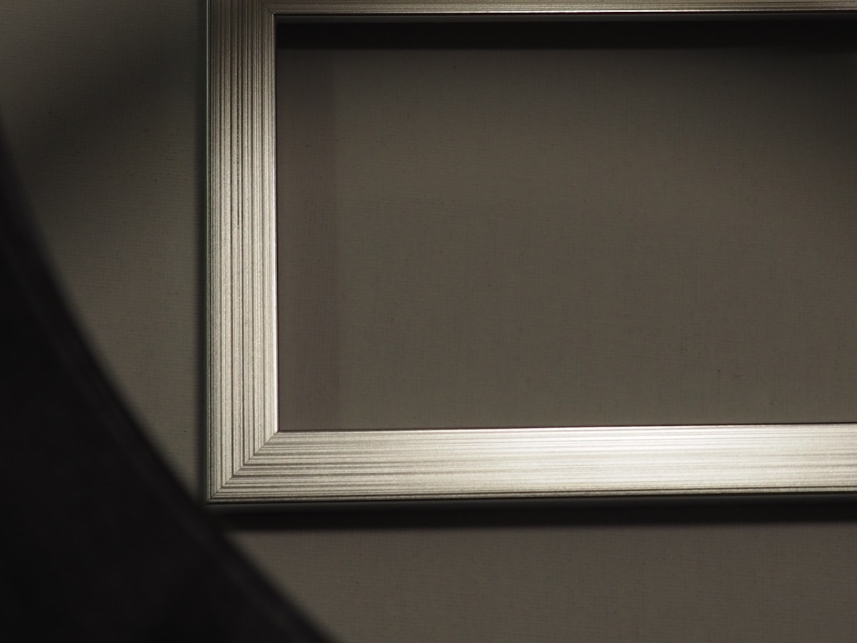 Empty ornate picture frame casting a shadow related to Transform Your Bedroom with a Sleek Silver Bed Frame