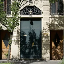Entrance with three doors and tree shadows. related to Transforming Your Home's Entryway: The Power of the Perfect Door