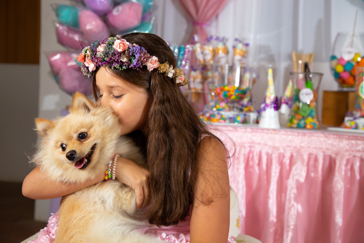 girl kissing dog while sitting near table related to Pawsome Snoozing: The Ultimate Guide to Princess Dog Bed