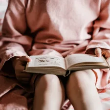 Girl reading a bedtime story book related to The Magic of Bedtime Stories: Timeless Tales for Tucking In