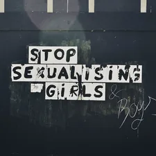 Graffitti on a construction wall at Connswater Community Greenway, County Down (May, 2020). The sign says "Stop Sexualising Girls and Boys." related to Unlocking Confidence: Exploring Sexuality in Bed