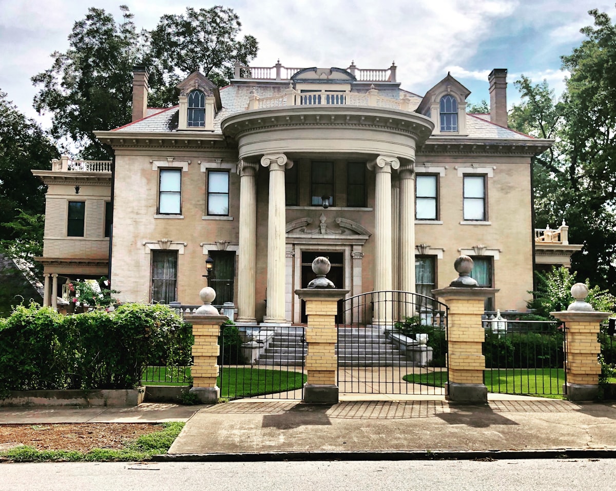 gray concrete pillared building surrounded by trees during daytime related to Discover the Luxury of DuPont Mansion Bed & Breakfast