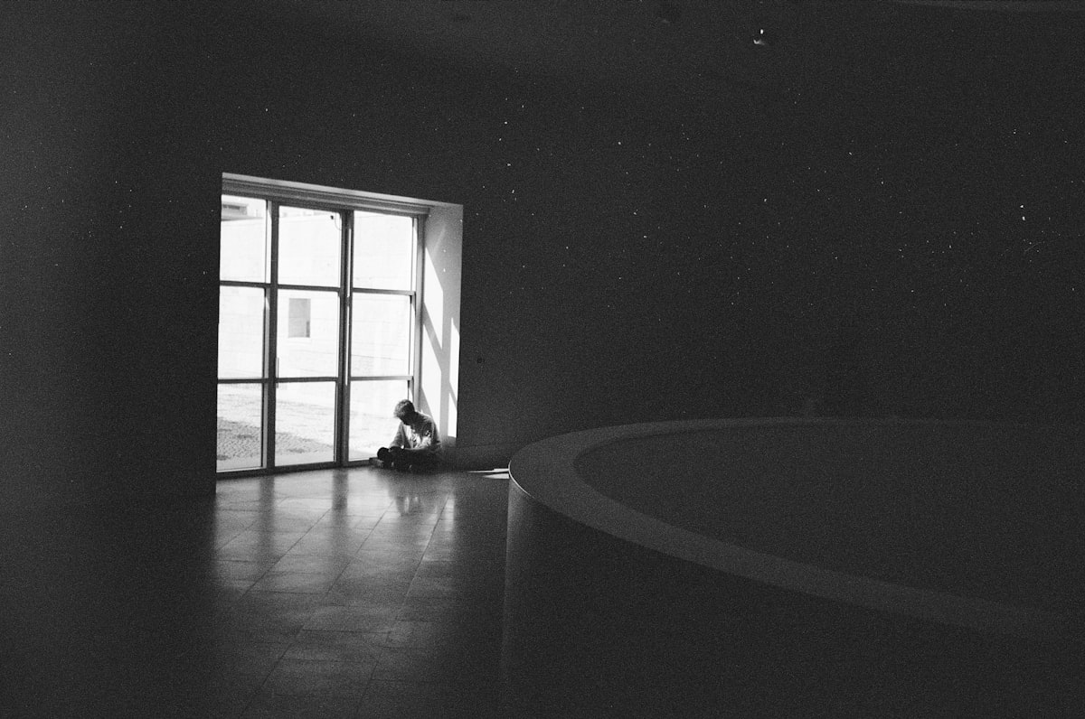 grayscale photo of person sitting on floor related to Essential Guide to Space Heaters from Bed Bath and Beyond
