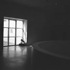 grayscale photo of person sitting on floor related to Essential Guide to Space Heaters from Bed Bath and Beyond