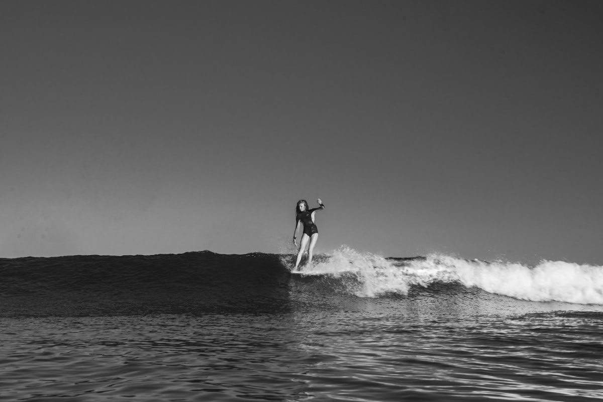 grayscale photo of woman surfboarding related to Riding the Wave of Style: The Best Southern Tide Bedding Options