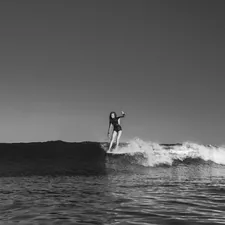 grayscale photo of woman surfboarding related to Riding the Wave of Style: The Best Southern Tide Bedding Options