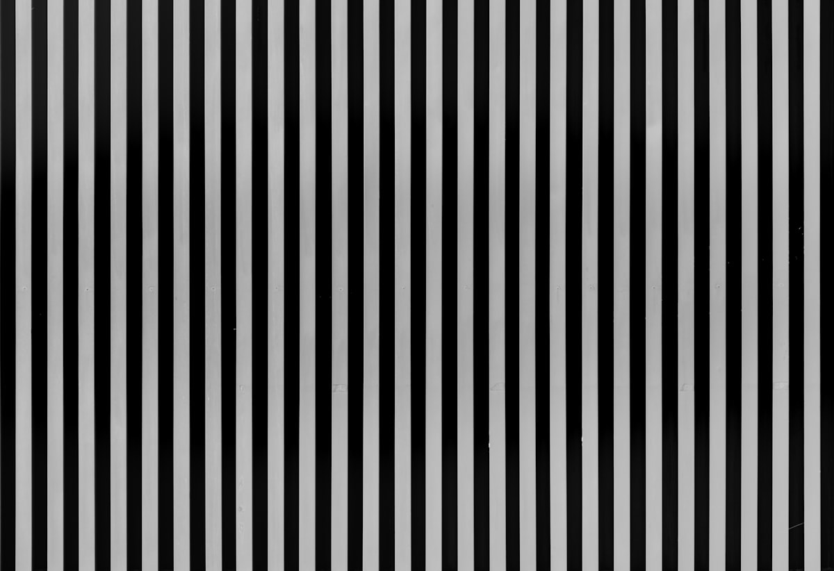Greyscale photo of striped wall. related to Elegant Black and White Stripe Valance: A Guide to Bedroom Decor