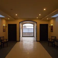 Hallway with doors, chairs, and arched window. related to Elevate Your Foyer with an Entryway Hall Tree Bench