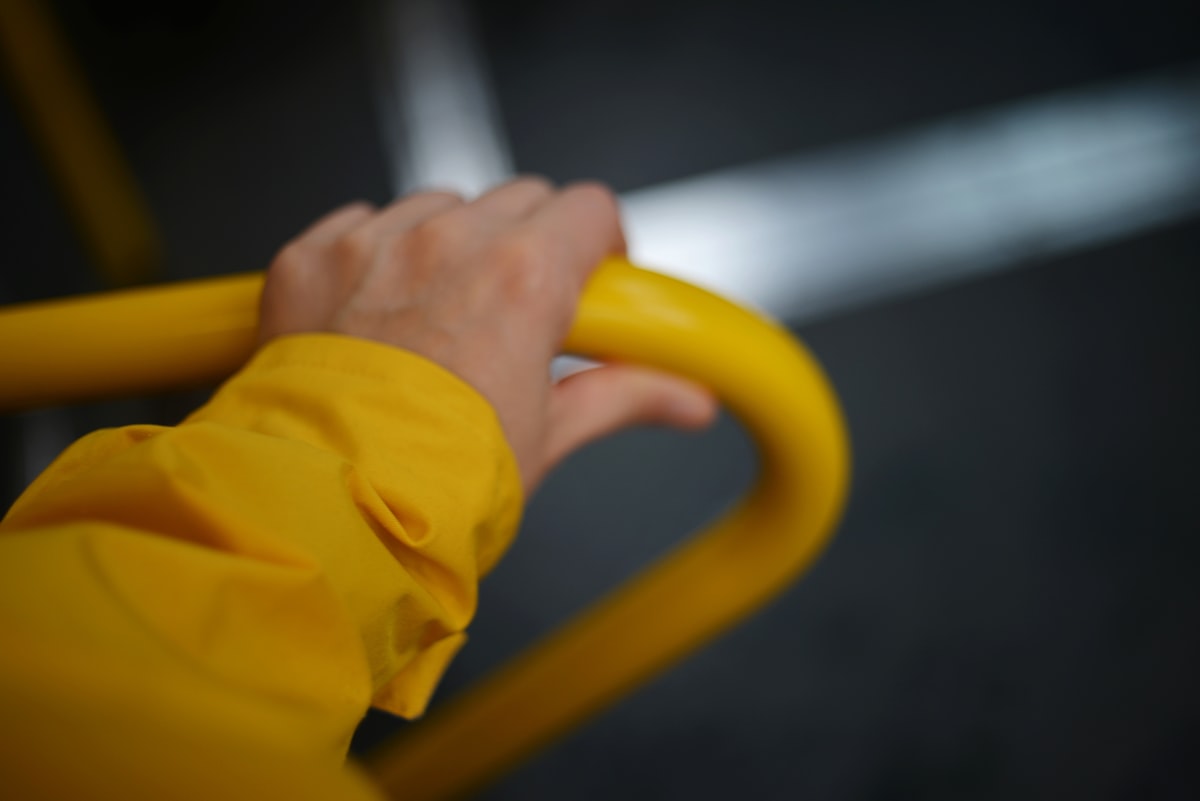 Hand holding a yellow bar with blurred background related to Enhancing Bed Accessibility and Safety