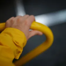 Hand holding a yellow bar with blurred background related to Enhancing Bed Accessibility and Safety