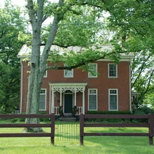 Historic Brick Home with white trim and ornate porch and 3 rail fence related to Discovering the Charm of Bed and Breakfasts in Ohio