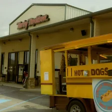 Hot dog cart outside a building with a sign. related to Ultimate Comfort: The Hot Dog Dog Bed Experience