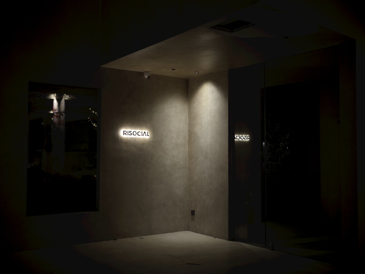 Illuminated sign on a textured wall at night related to Illuminating Your Home: A Guide to Entryway Lights Ceiling