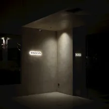 Illuminated sign on a textured wall at night related to Illuminating Your Home: A Guide to Entryway Lights Ceiling