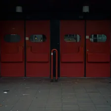 Large red doors with glass panels and metal accents. related to The Evolution of Front Entryway Doors: Design Trends and Features