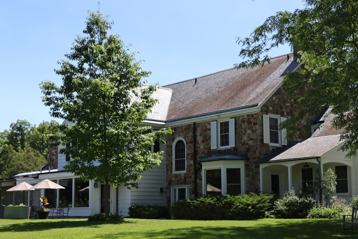 Large stone and white house with green lawn and trees. related to Discovering the Charm of Bed and Breakfasts in Ohio