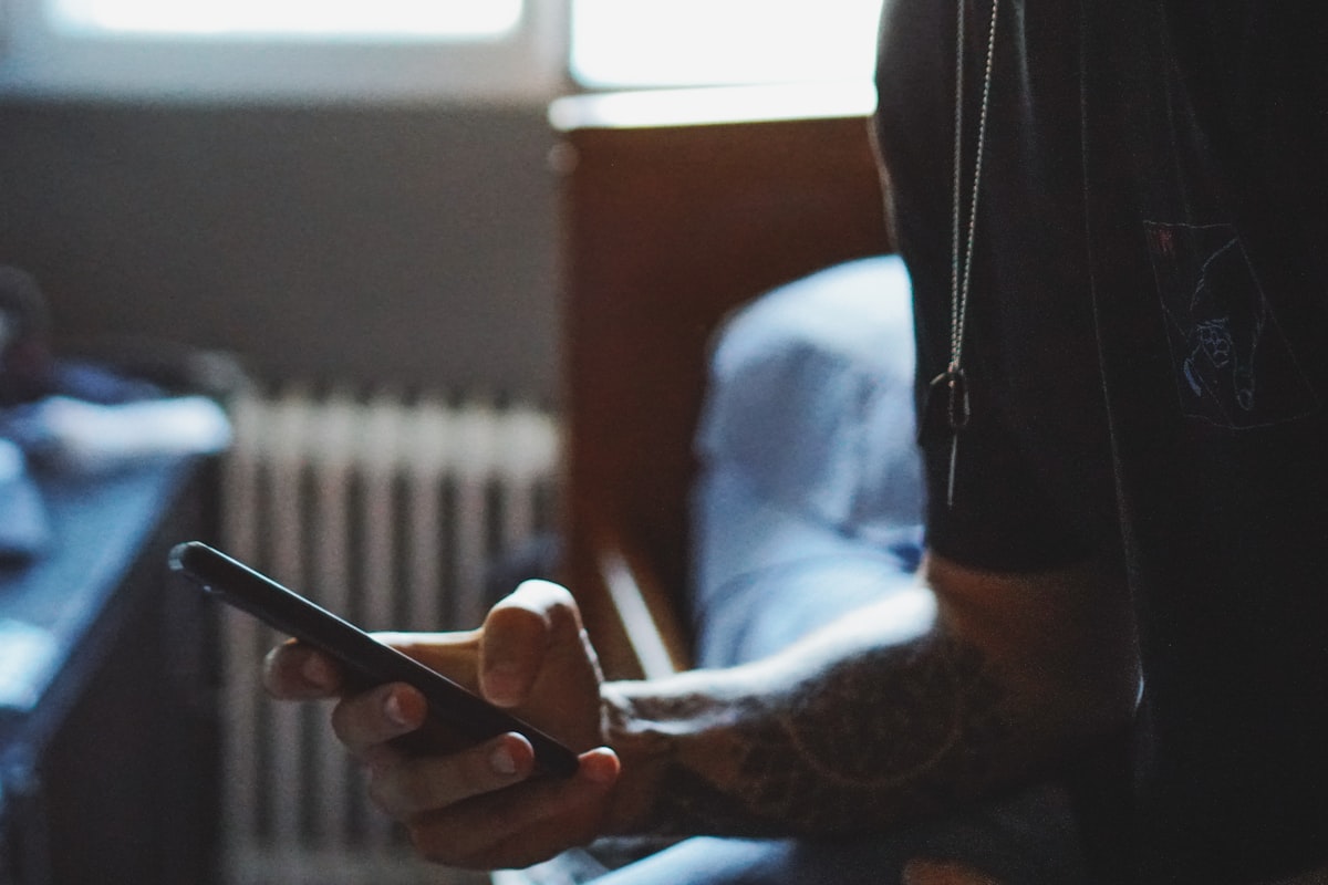 man holding black phone related to Unlock Exclusive Savings: Bed Bath and Beyond Mobile Coupon Guide