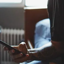 man holding black phone related to Unlock Exclusive Savings: Bed Bath and Beyond Mobile Coupon Guide
