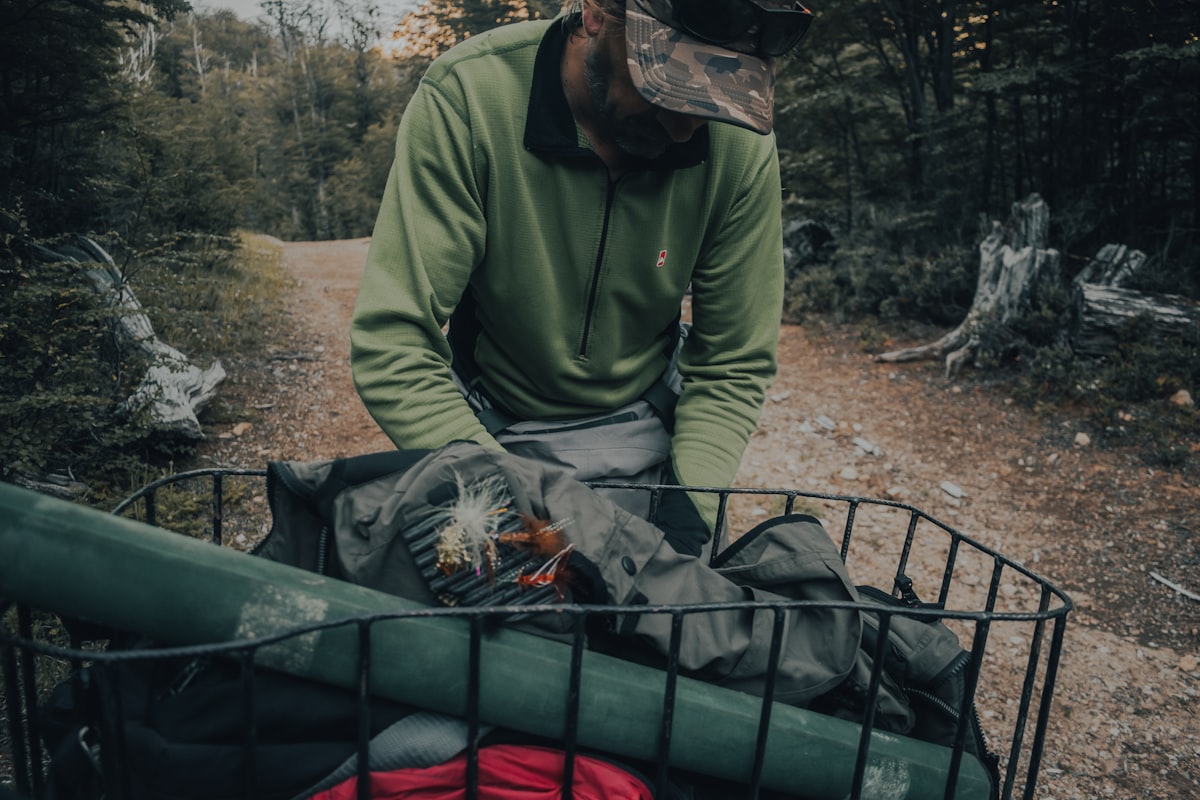man in green jacket sitting on green plastic chair related to The Ultimate Hunting Bed Sets Guide
