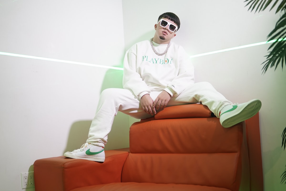 man in white hoodie sitting on red couch related to Level Up Your Lounge: Swag Curtains with Valance