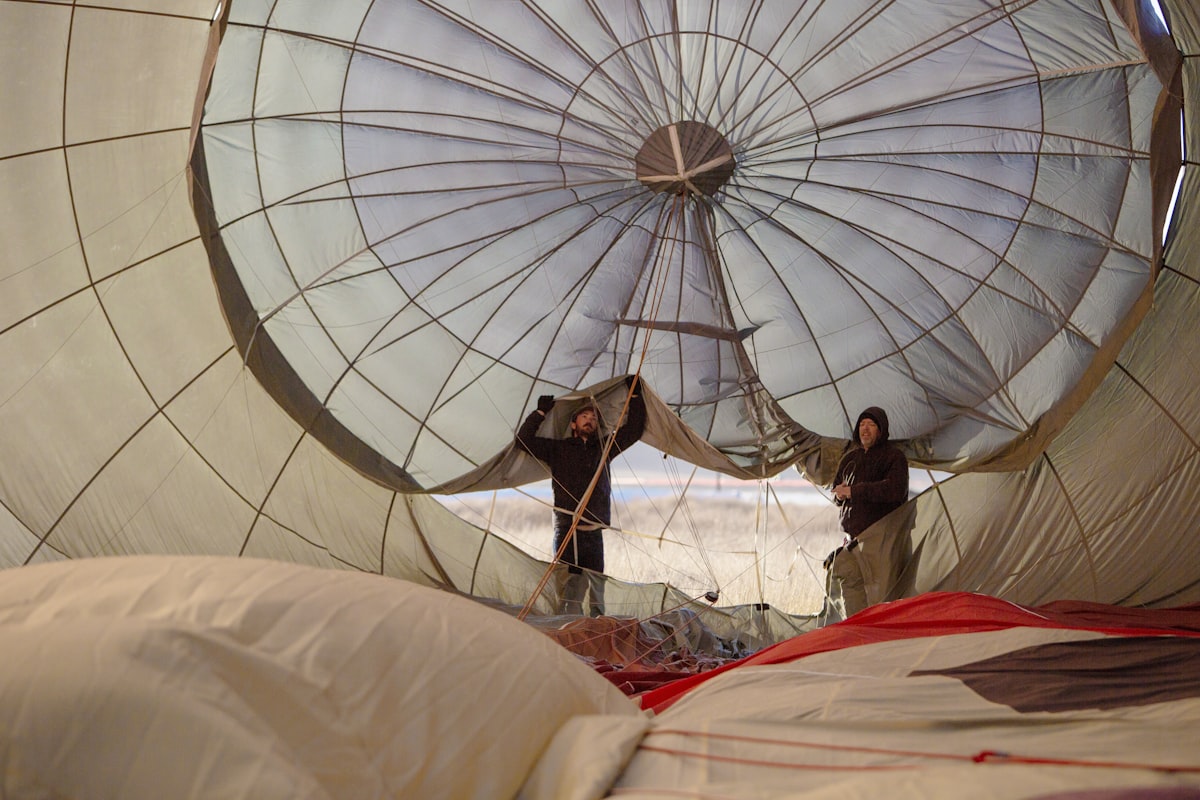 man in white thobe sitting on white textile related to Elevate Your Sleep with Hot Air Balloon Bedding