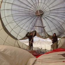 man in white thobe sitting on white textile related to Elevate Your Sleep with Hot Air Balloon Bedding