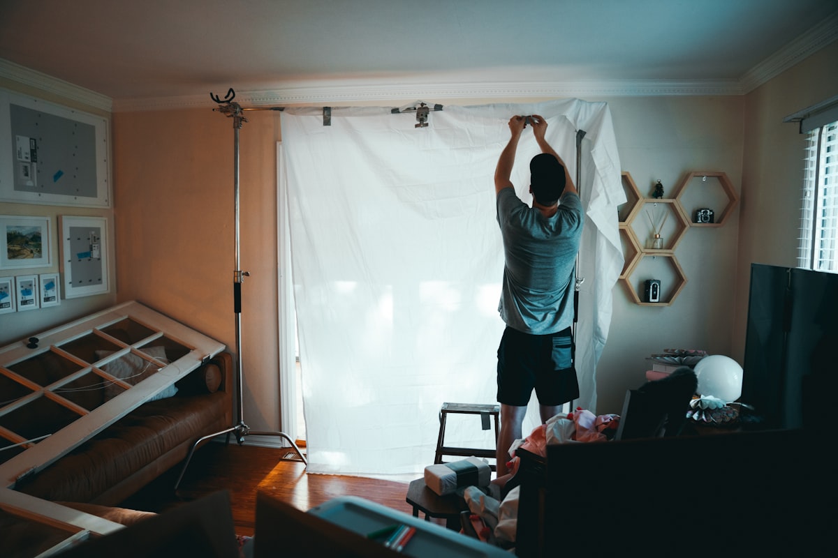man standing beside white curtain related to Window Valances: Elevate Your Interior Style