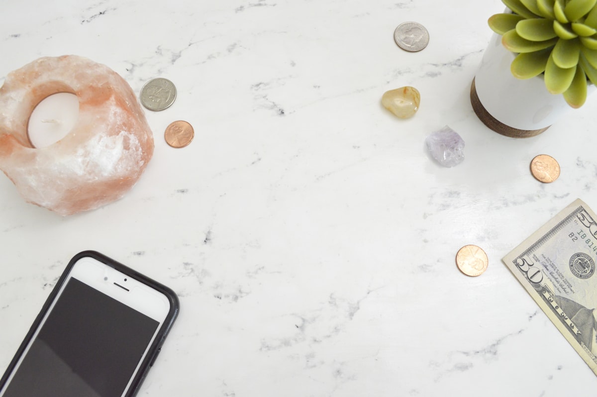 Marble styled stock photo flatlay with money, phone, succulent, and Himalayan salt candle for bloggers and female entrepreneurs. related to Exclusive Savings on Home Essentials