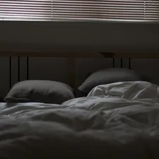 Messy bed and closed blinds related to Decoding the Mystery: What Do Bed Bug Bites Look Like?