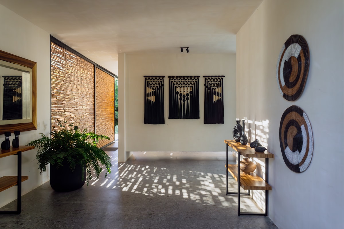Modern hallway with decorative wall hangings and plants. related to Elegant Entryway Table Decor Ideas to Create a Lasting Impression