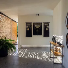 Modern hallway with decorative wall hangings and plants. related to Elegant Entryway Table Decor Ideas to Create a Lasting Impression