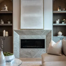 Modern living room with a fireplace and sofa. related to Elevate Your Home with Style: The Benefits of Window Wood Valance