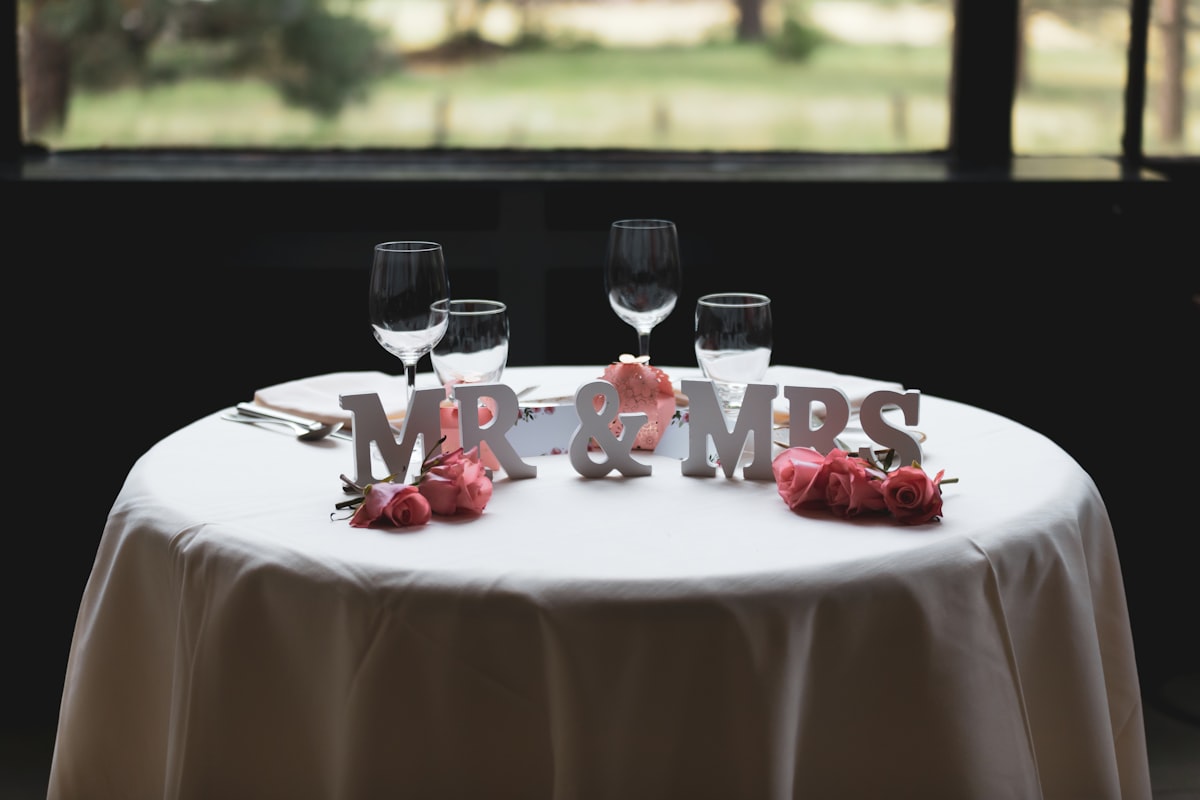 Mr & Mrs freestanding letter on table with four wine glasses related to Cozy Slumber: The Ultimate Guide to Mr and Mrs Bedding Sets