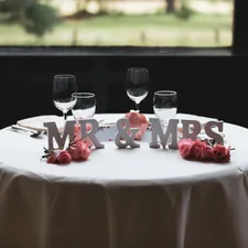 Mr & Mrs freestanding letter on table with four wine glasses related to Cozy Slumber: The Ultimate Guide to Mr and Mrs Bedding Sets