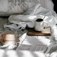 Mug and notebooks on bed related to Bed Bath & Beyond Hours: Your Guide to Shopping Convenience