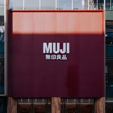 Muji store facade with large red sign related to Minimalist Sleep Solutions for Every Bedroom