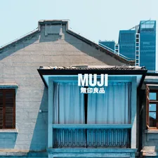 Muji store facade with modern buildings behind old building related to Minimalist Sleep Solutions for Every Bedroom