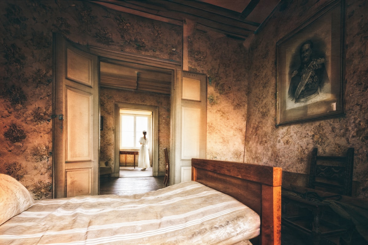 Old bedroom with a figure in the doorway. related to Decadent Sleep: The Allure of Vintage Bed Frames