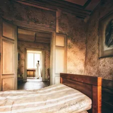 Old bedroom with a figure in the doorway. related to Decadent Sleep: The Allure of Vintage Bed Frames