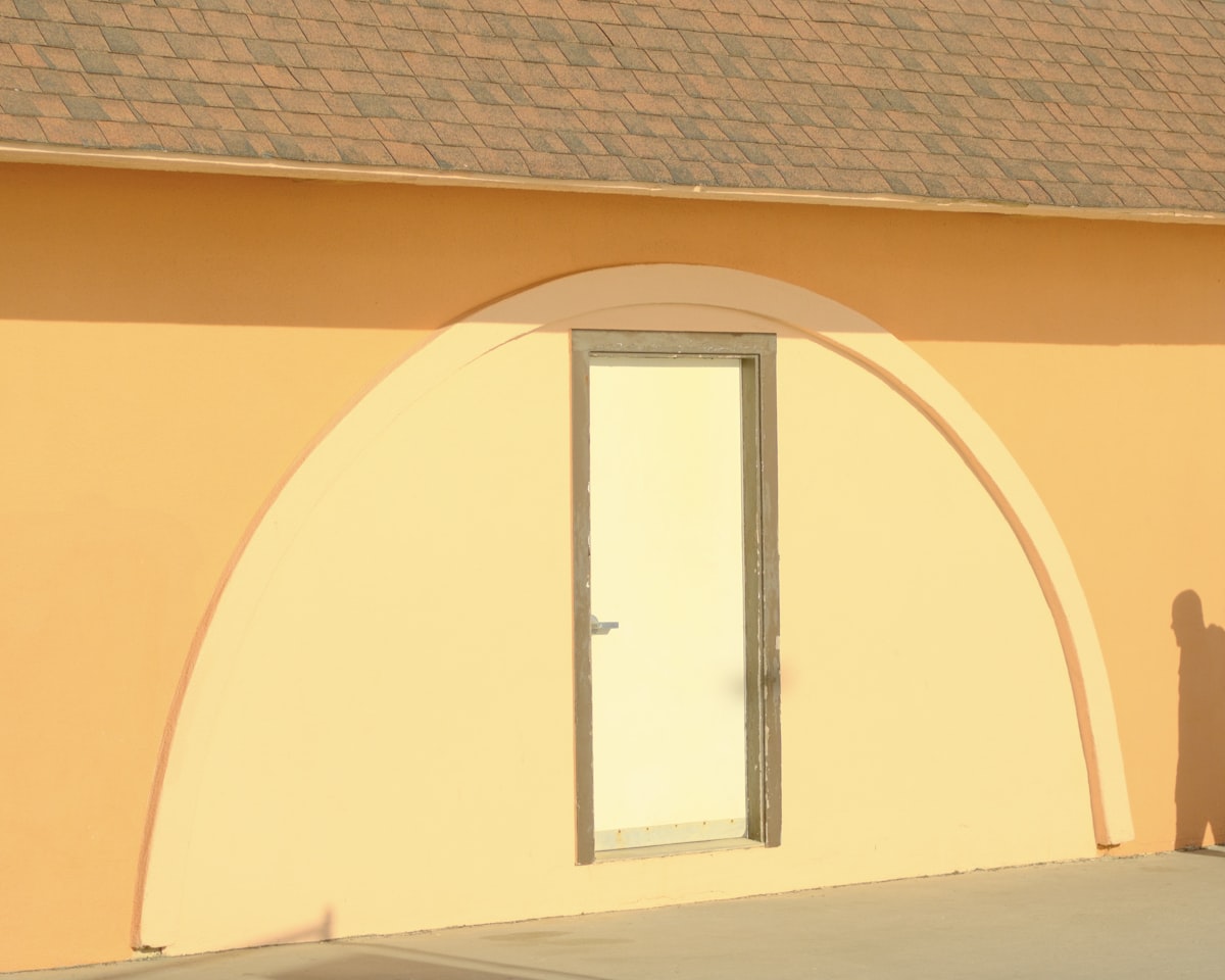 Orange building with a rounded archway over a door related to Elevate Your Home's First Impression: Entryway Wall Colors