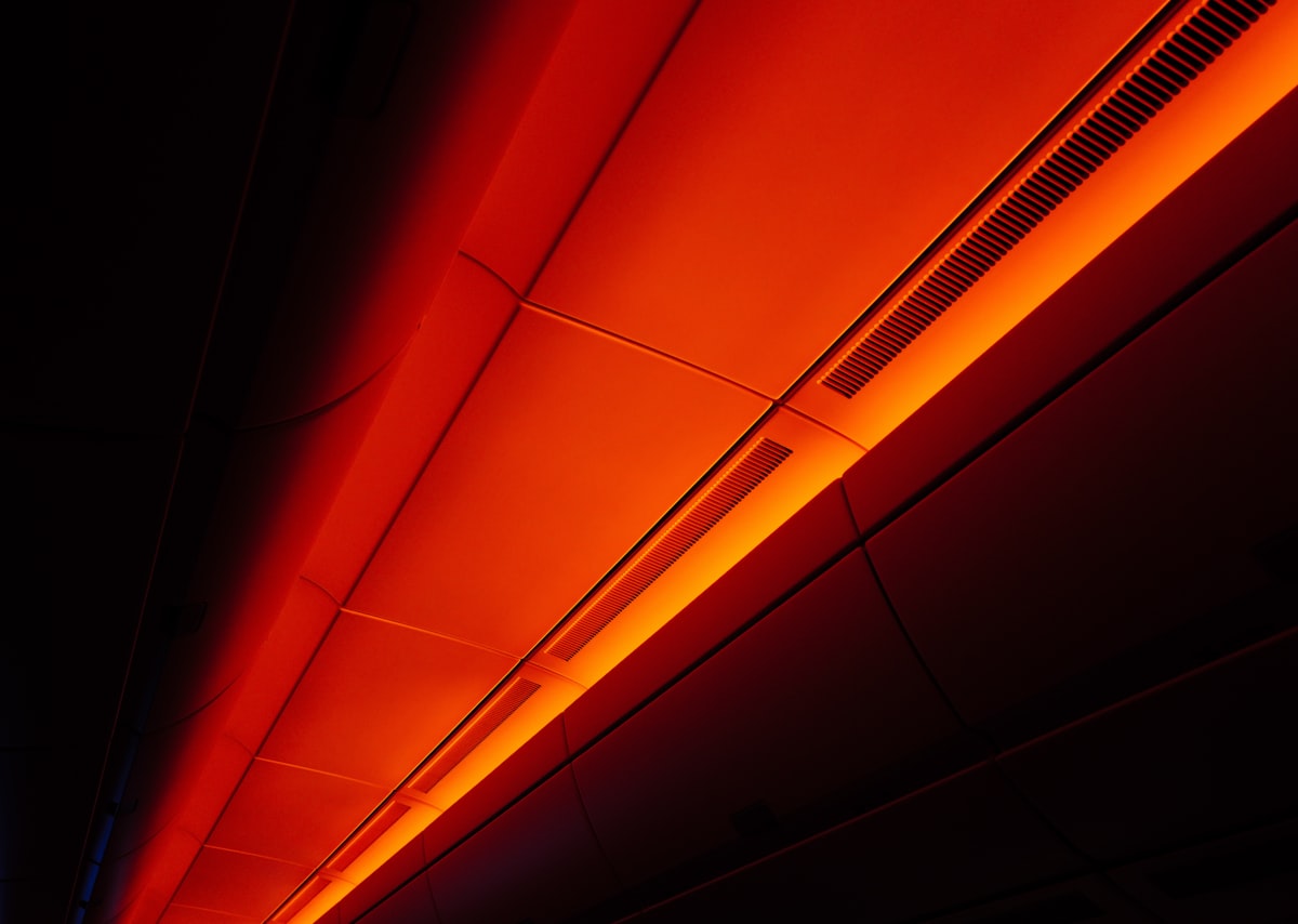Orange light illuminates a dark ceiling panel related to The Benefits and Risks of Using a Red Light Tanning Bed