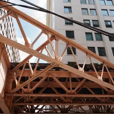 Orange metal truss structure against city buildings and sky related to Creating Your Own Elevated Garden Bed