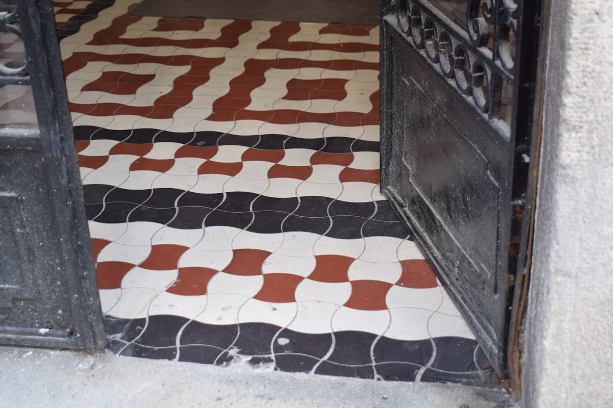 Ornate geometric floor tiles in black, white, and red. related to Transforming Your Home's First Impression: Entryway Tile Patterns