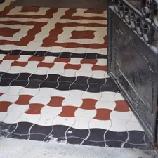 Ornate geometric floor tiles in black, white, and red. related to Transforming Your Home's First Impression: Entryway Tile Patterns