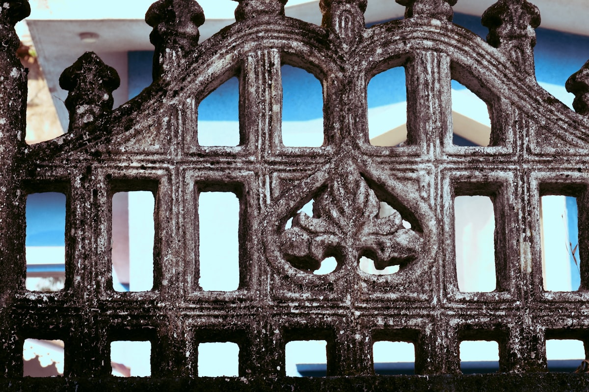 Ornate stone fence with decorative carvings related to Wrought Iron Bed Frames - Elevate Your Home's Style